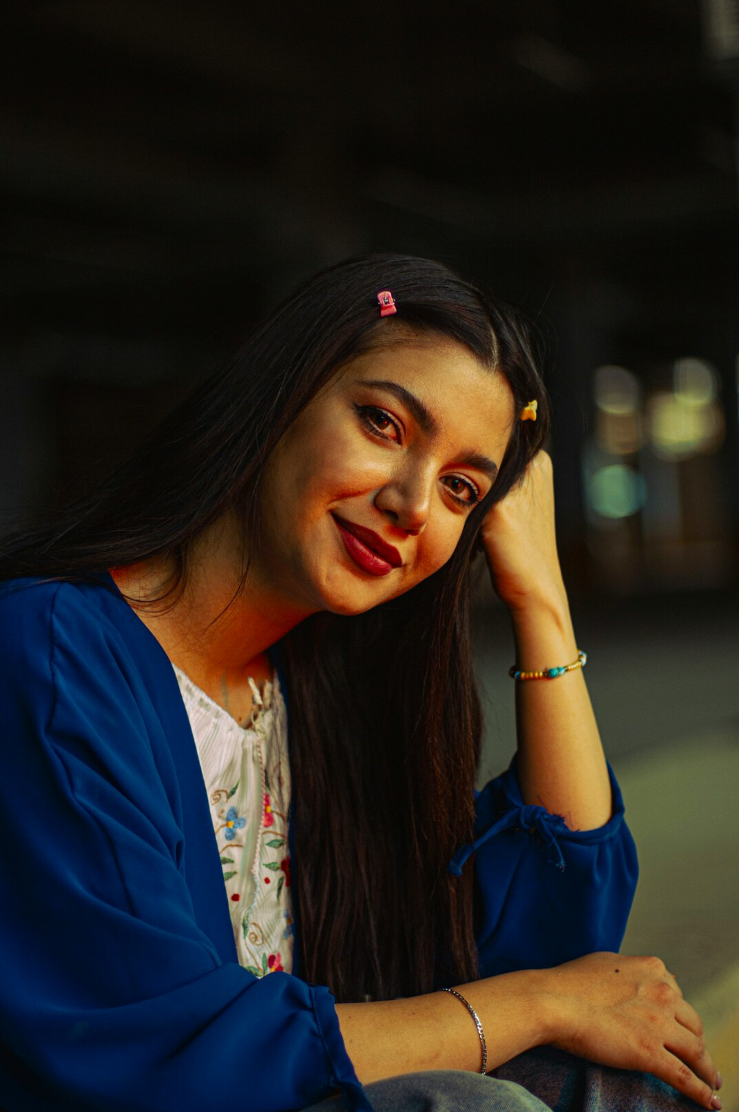 Portrait of a smiling woman with long dark hair wearing a navy blazer