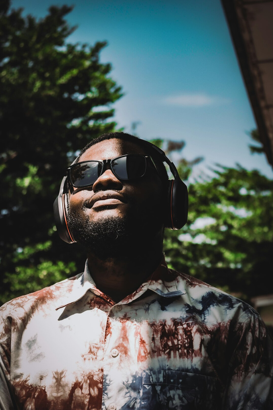 Portrait of a bearded man in a casual shirt with headphones around his neck